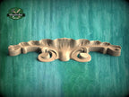 A wooden carving or mold is displayed against a green background.