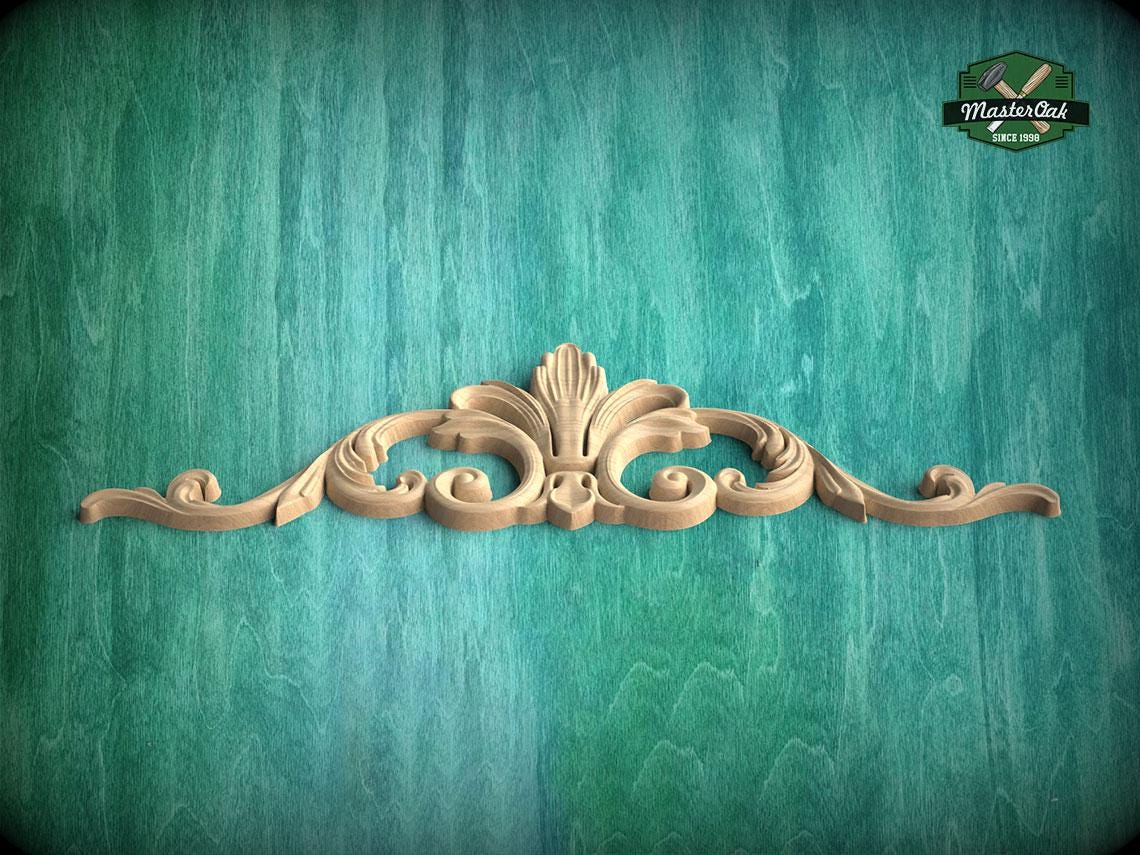 A decorative wooden carving in the shape of a fan is displayed against a green textured background.