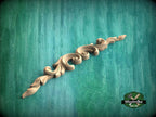 A decorative wooden carving with a scroll-like design is displayed against a green textured background.
