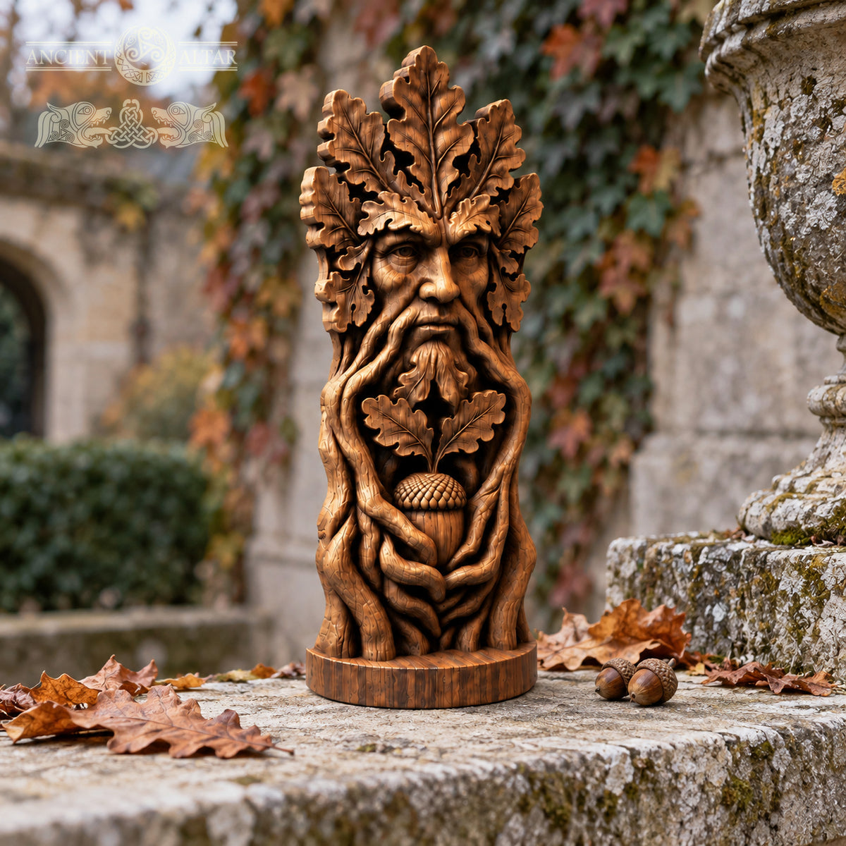 A wooden sculpture of a face with a beard and leaves adorns a stone pedestal, surrounded by fallen autumn leaves.