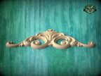 A decorative wooden carving in the shape of a scroll adorns a turquoise background.