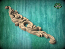 Load image into Gallery viewer, A decorative wooden carving with intricate swirls and curves is displayed against a teal-colored background.
