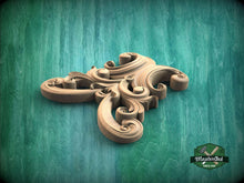 Load image into Gallery viewer, A wooden carving with intricate scrollwork is displayed against a green background.
