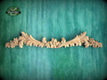 a wood carving of flowers and leaves on a green background
