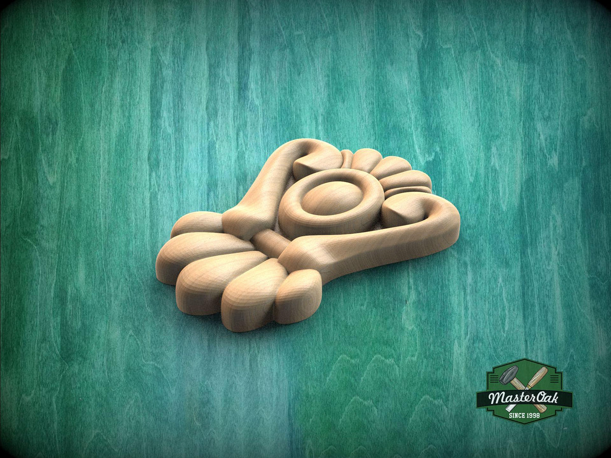 A wooden carving of a flower-like design is displayed against a green background.