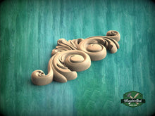 Load image into Gallery viewer, A decorative wooden ornament with a floral design is displayed against a green background.
