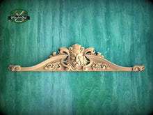 Load image into Gallery viewer, a carved wooden mold or sculpture with an intricate design, set against a green textured background.
