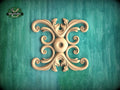 a decorative wooden carving with an intricate design on a green background.