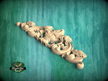 Load image into Gallery viewer, A decorative wooden carving with intricate scrollwork and floral elements is displayed against a teal background.

