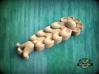 A wooden flower-shaped object with a curved petal design is shown against a green background.