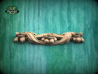 A wooden carving of a floral design is displayed against a green textured background.