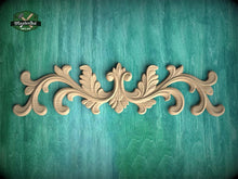 Load image into Gallery viewer, a decorative wooden carving on a teal background.
