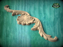 Load image into Gallery viewer, A decorative wooden carving with an ornate, wing-like design is displayed against a green textured background.
