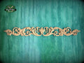 A decorative wooden carving with an intricate floral design is displayed against a textured green background.