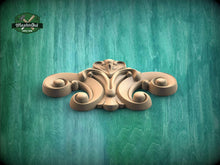 Load image into Gallery viewer, A wooden carving with an intricate, decorative design is displayed against a green textured background.
