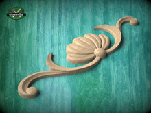 Load image into Gallery viewer, A wooden carving of a shell-like design is displayed against a teal-colored background.
