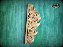 Load image into Gallery viewer, A decorative wooden carving with intricate scrollwork is displayed against a green textured background.
