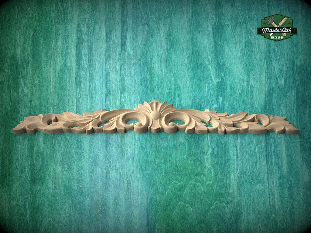 A decorative wooden carving or panel with an ornate, floral design is displayed against a textured green background.