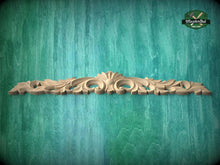Load image into Gallery viewer, A decorative wooden carving or panel with an ornate, floral design is displayed against a textured green background.
