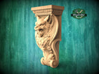 A carved wooden bracket with a detailed wolf or wolf-like creature design, set against a green background.