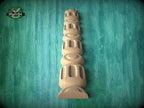 A wooden carving of a tall, cylindrical object with a series of smaller cylindrical shapes stacked vertically, set against a green textured background.