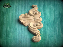 Load image into Gallery viewer, A carved wooden ornament with a floral design is displayed against a green background.
