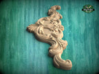 A decorative wooden carving with intricate floral and scrollwork designs is displayed against a green background.