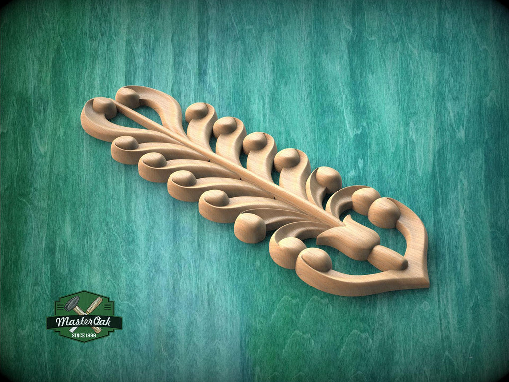 A decorative wooden leaf-like object with intricate patterns and designs, resting on a green textured background.