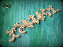 Load image into Gallery viewer, A decorative wooden carving with intricate scrollwork is displayed against a teal background.

