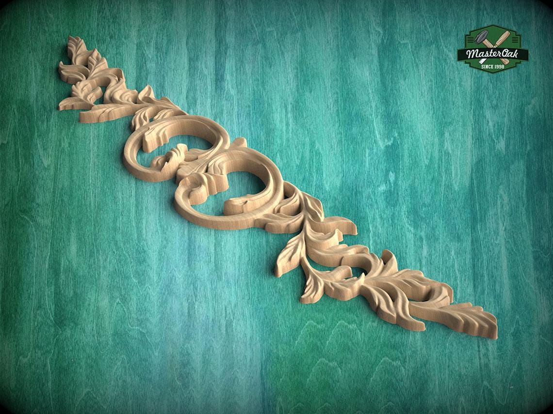 A decorative wooden carving with intricate leaf-like patterns is displayed against a green textured background.