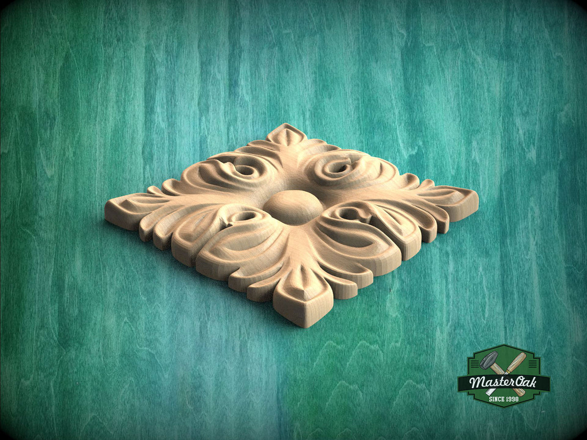 A decorative wooden panel with an intricate floral design, placed on a green textured background.