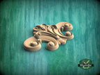A wooden carving with an intricate, swirling design sits on a green textured background.