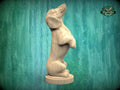 A wooden sculpture of a dog standing on its hind legs, with a green background.