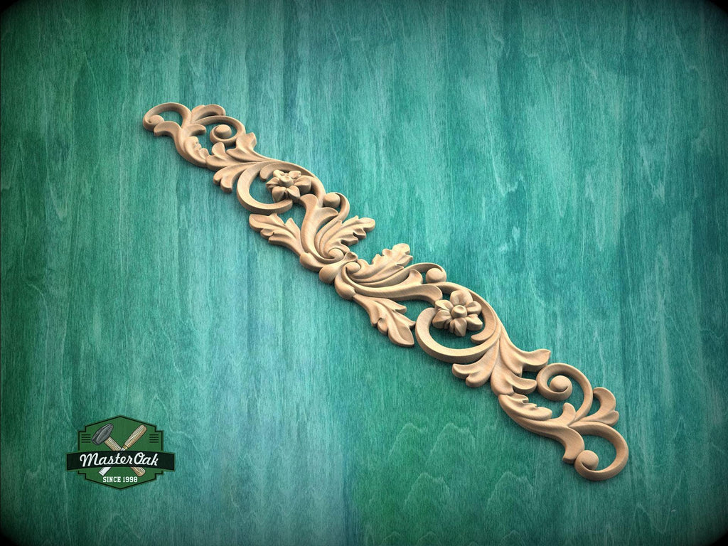 A decorative wooden carving with intricate floral and scroll designs is displayed against a green textured background.