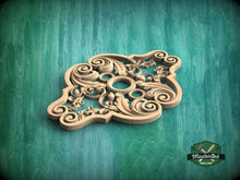 Load image into Gallery viewer, A decorative wooden carving with intricate swirls and patterns is displayed against a green background.
