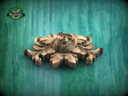A wooden carving of a flower with intricate details is displayed against a green background.