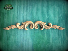 Load image into Gallery viewer, A decorative wooden scrollwork piece with intricate scrollwork and floral elements is displayed against a green textured background.
