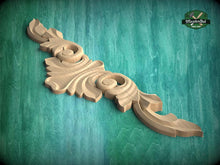 Load image into Gallery viewer, A wooden carving with an intricate, decorative design is displayed against a green background.
