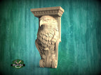 A carved wooden eagle sculpture is displayed against a green background.