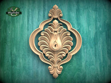 Load image into Gallery viewer, a decorative wooden carving on a green background.
