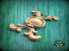Load image into Gallery viewer, A wooden carving with intricate designs is displayed against a green background.
