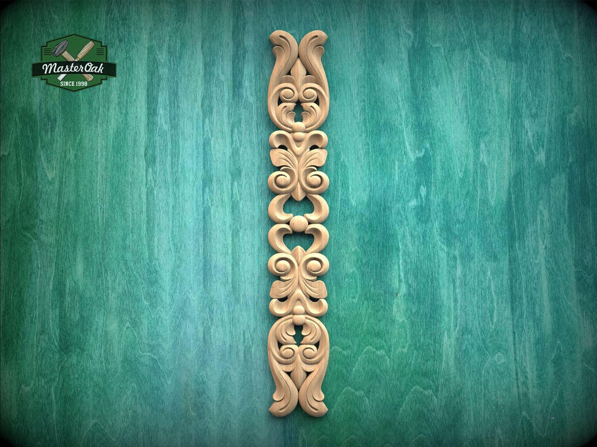 A decorative wooden carving in the shape of a vertical column with intricate scrollwork is displayed against a green textured background.
