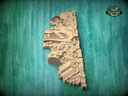 A wooden carving of a bird or bird-like figure is displayed against a green background.