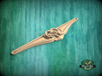 A wooden carving or sculpture is displayed against a green background.