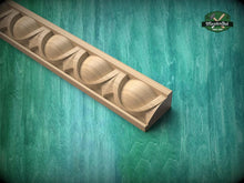 Load image into Gallery viewer, A wooden carving with a curved design is displayed against a green background.
