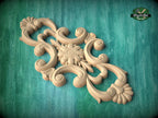 A decorative wooden carving with intricate floral and scroll designs is displayed against a green background.