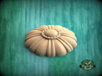 A wooden flower-shaped object is displayed against a green background.