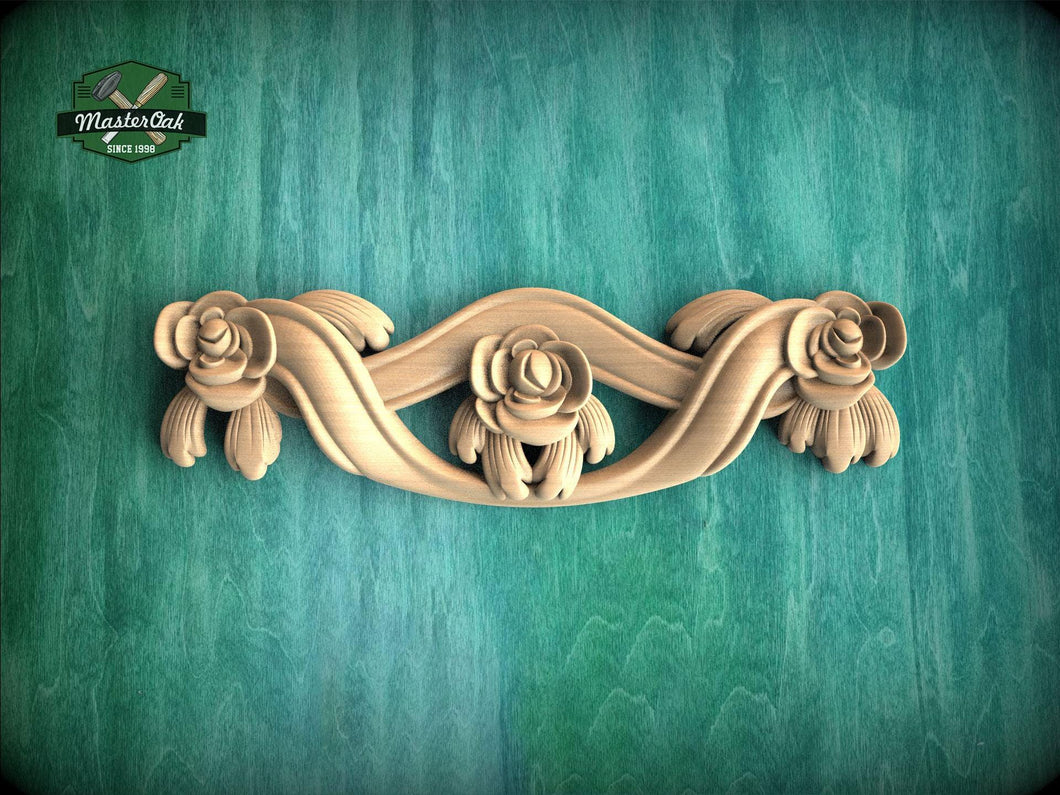 A decorative wooden carving of a floral design on a green background.