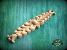Load image into Gallery viewer, A wooden carving with a floral design is displayed against a green background.
