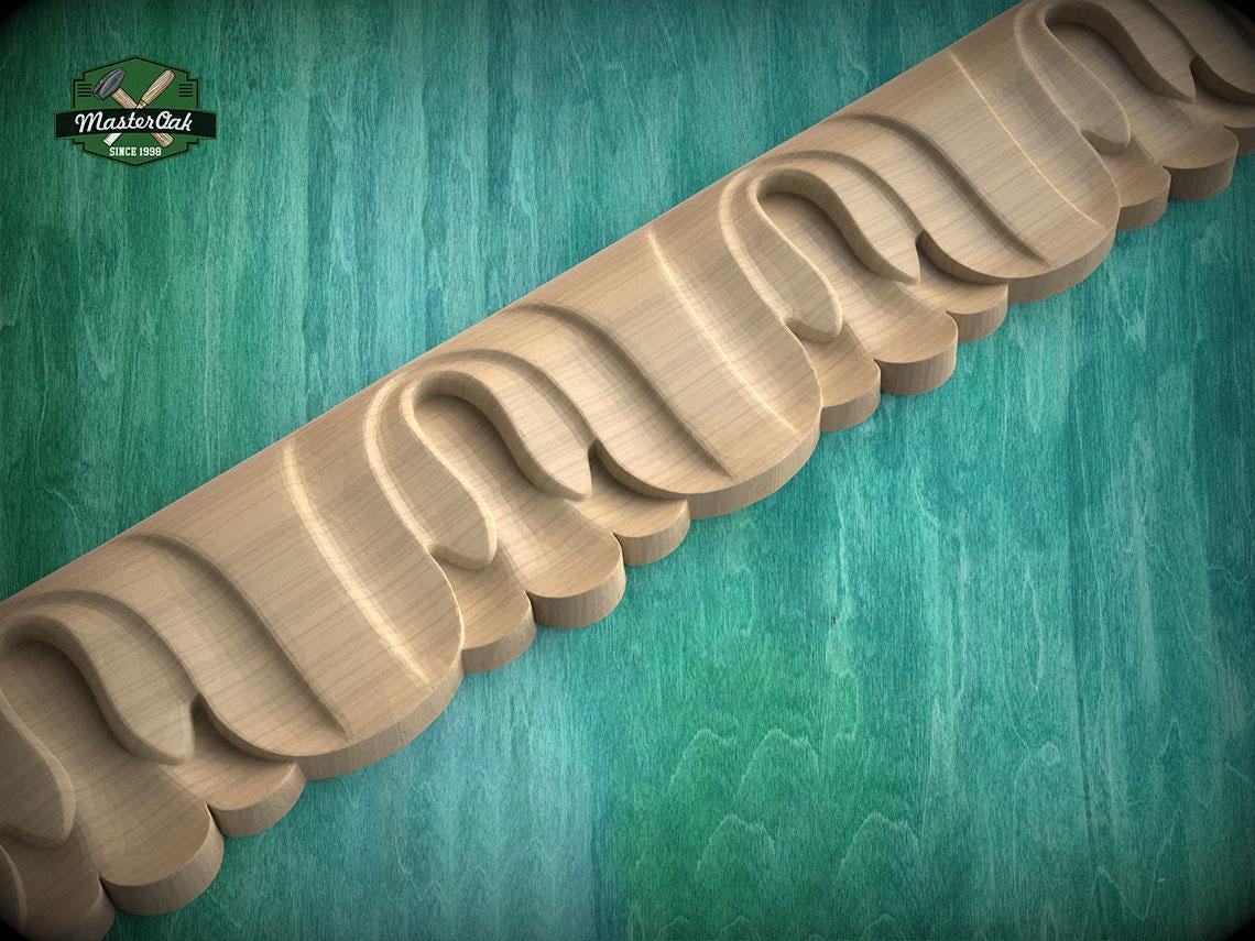 A wooden carving with a curved, organic design is displayed against a teal-colored background.